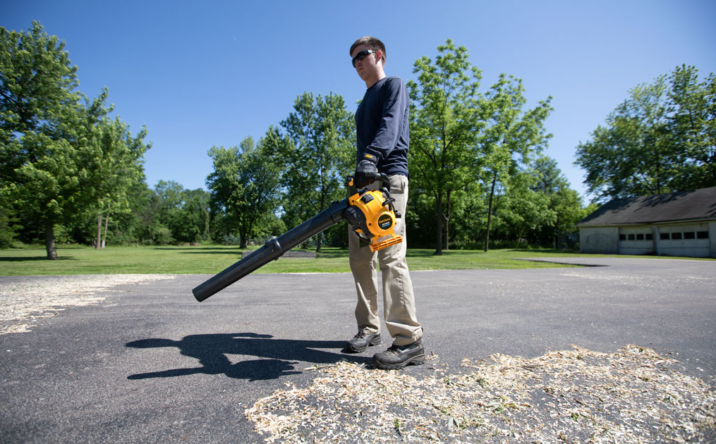 Man using leaf blower on driveway