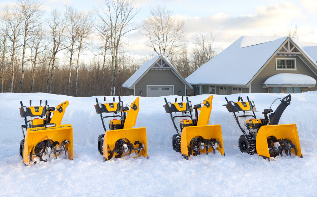 Three Cub Cadet series snow blowers lined up outside on the snow