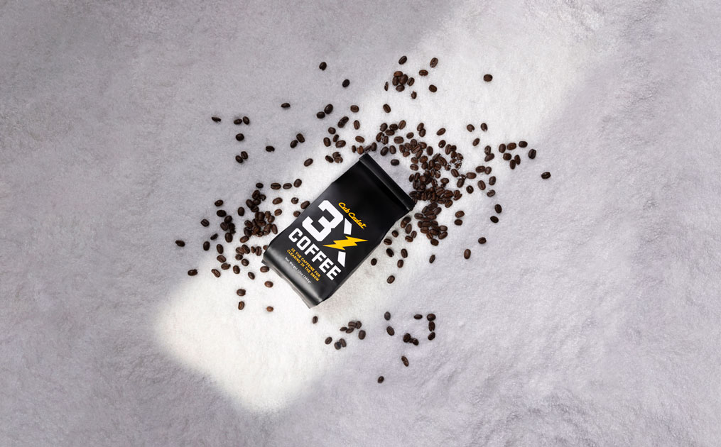 3X coffee and coffee beans sitting in snow
