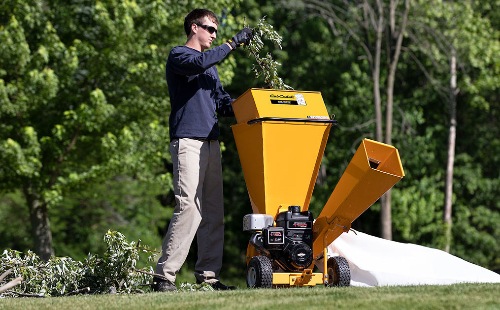 Man putting branches into a shredder