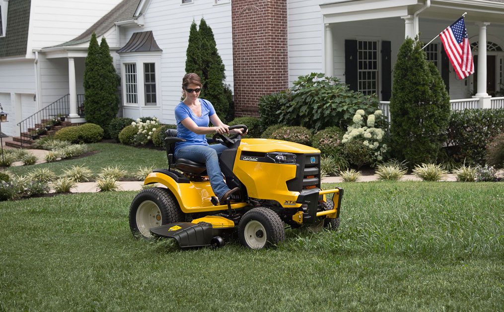 woman cutter her lawn with riding mower