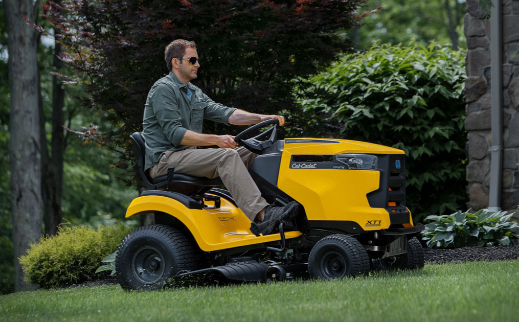 man cutting his grass with an electric riding lawn mower