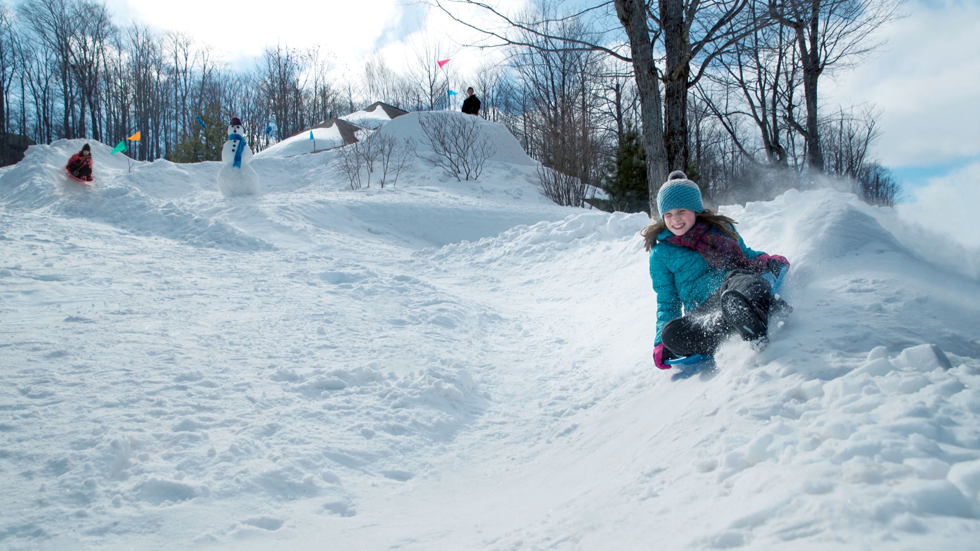girl sledding down homemade snow track