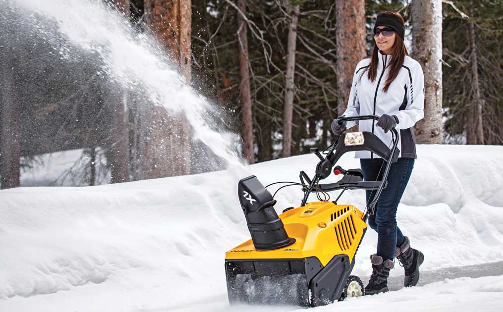 woman snow blowing with 1X single stage snow blower