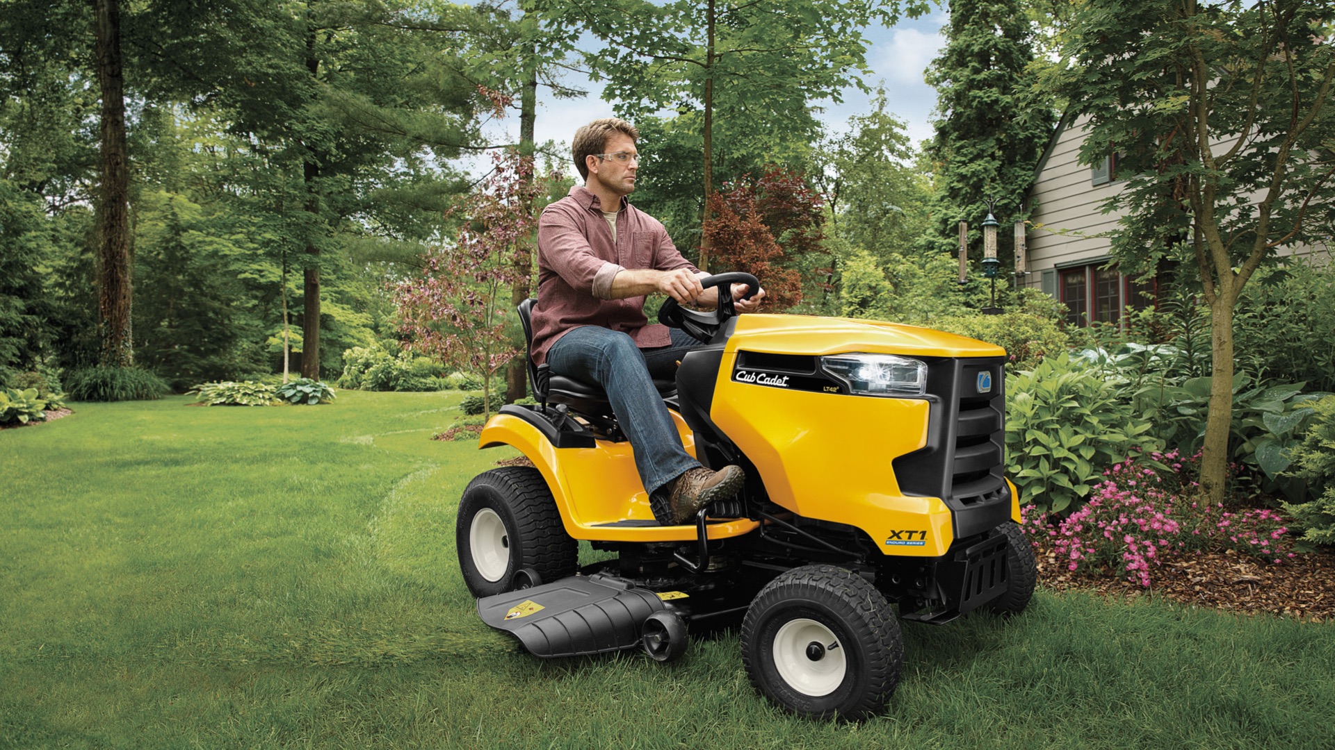 man mowing his yard with a lawn tractor