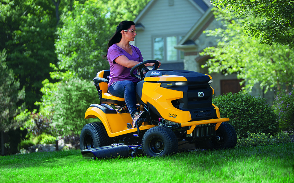 woman mowing grass with a Cub Cadet riding lawn mower
